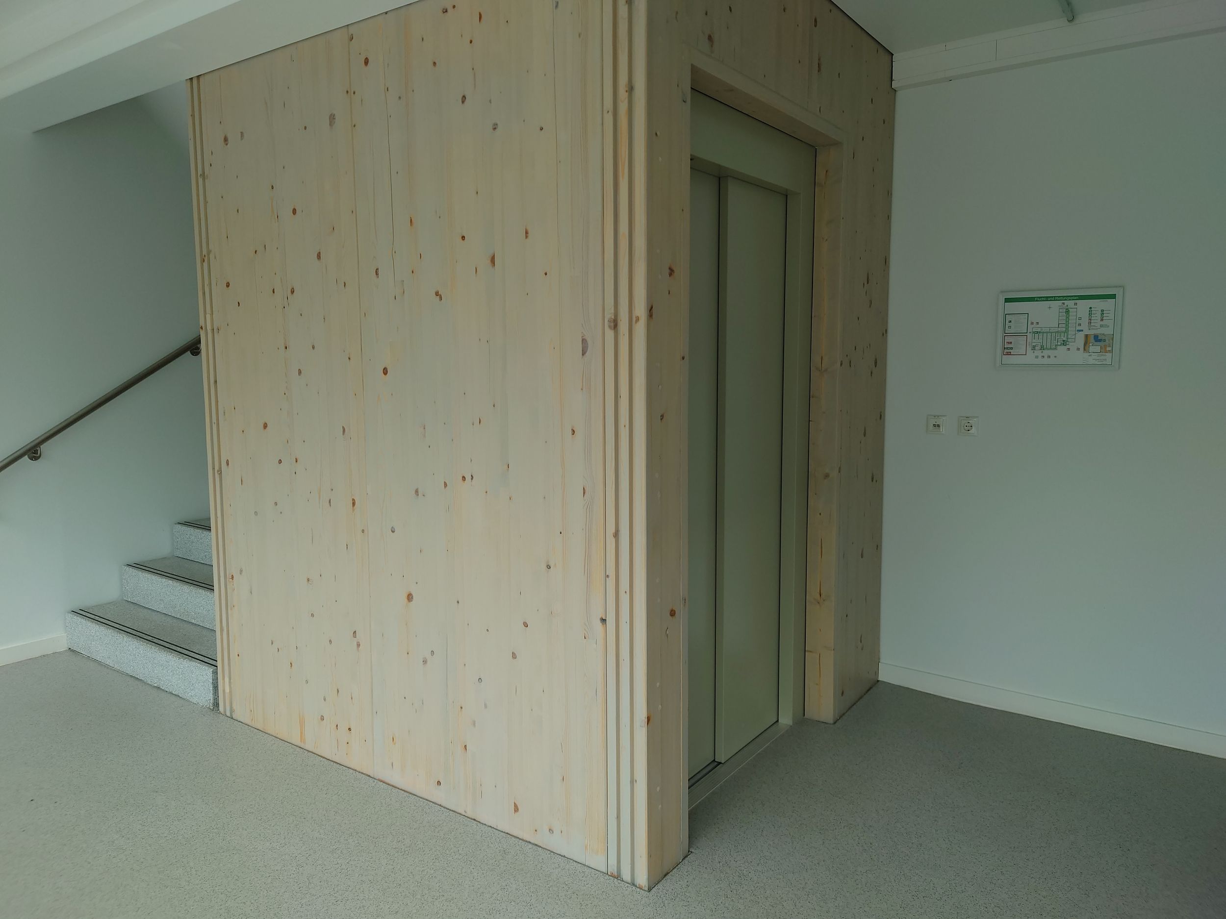 Detailaufnahme des Personenaufzugs im AVG Gebäude mit einem hölzernen Aufzugsschacht
