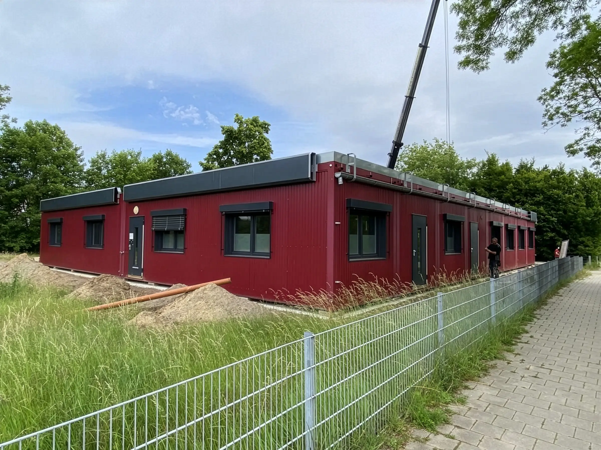 Aufnahme der einstöckigen Raummodulanlage-KiTa in Rheine mit einem Mobilkran dahinter