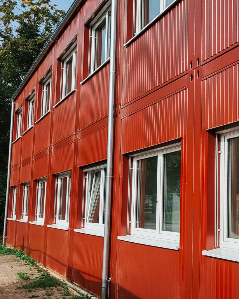Erweiterung der Alexander-von-Humboldt-Schule in Rheine 4 Detailaufnahme der roten Fassade der zweistöckigen Erweiterung in Modulbauweise in Rheine